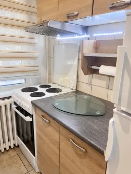 Manja kuhinja sa drvenim elementima, šporetom i radnom površinom. - image 12