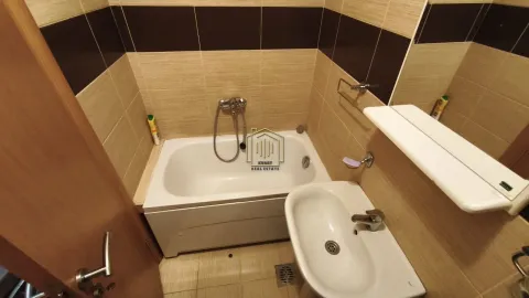 Small bathroom with a bathtub, washbasin, and brown-toned tiles. - image 2