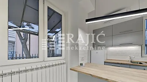 Modern kitchen with grey cabinets and a wooden countertop. - image 11