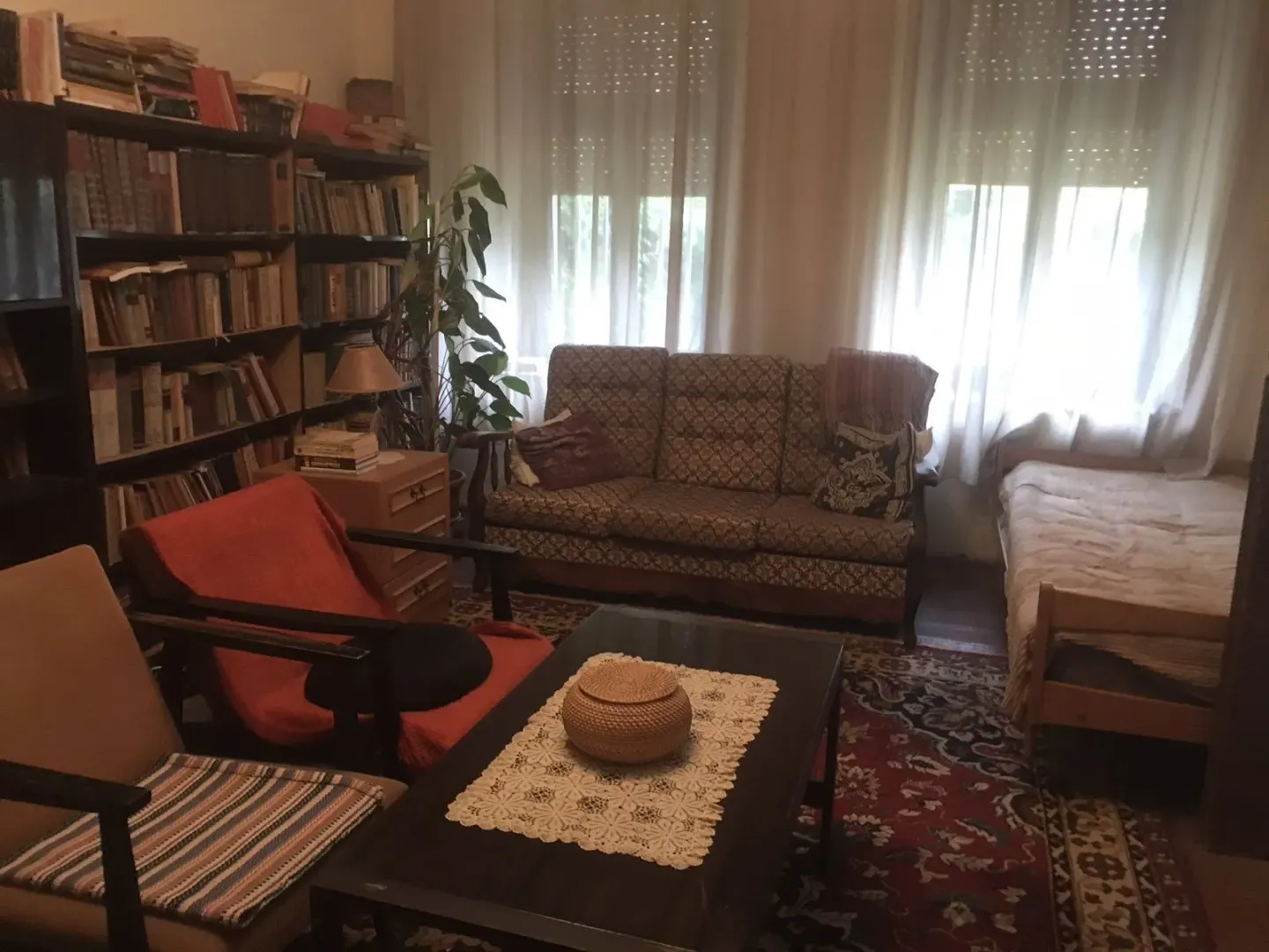 Dnevna soba sa garniturom za sjedenje, policama za knjige i tepihom.