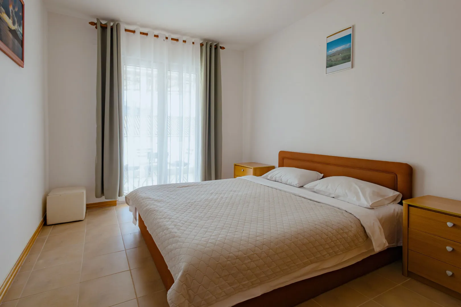 Tidy bedroom with a double bed, nightstands, and access to the terrace.