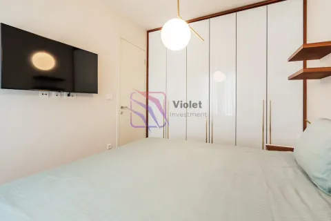 Modern bedroom with a double bed, built-in wardrobe and a wall-mounted TV. - image 7