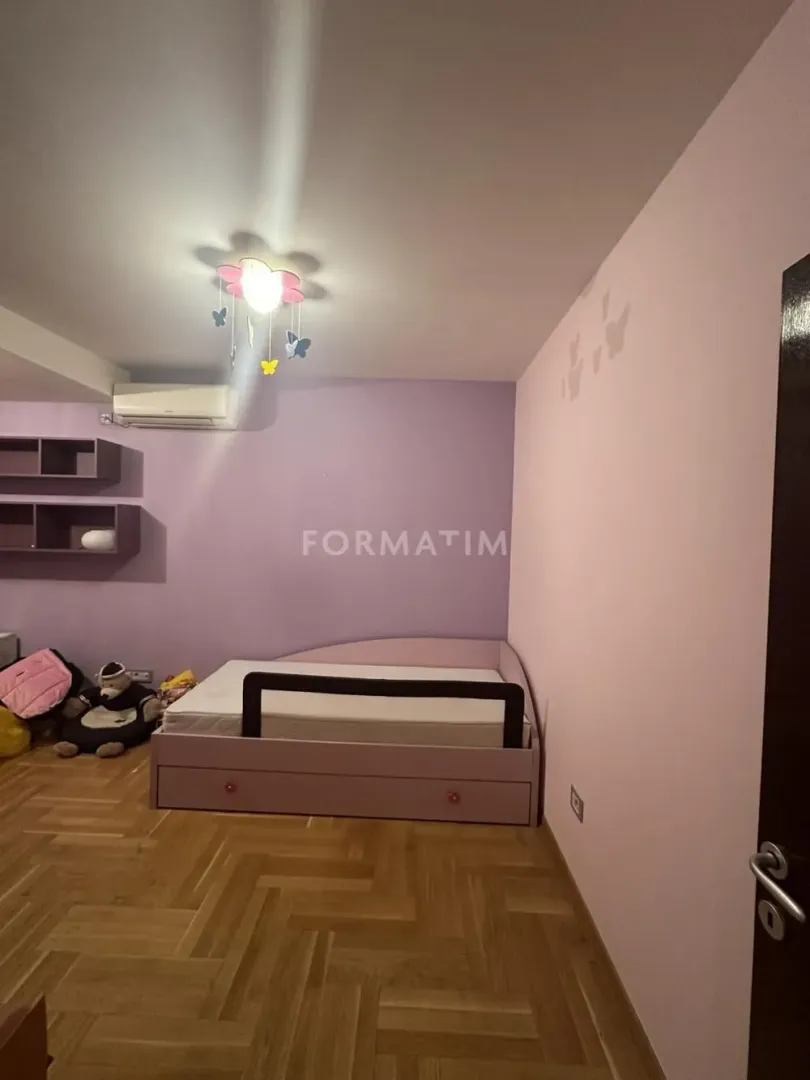 Children's bedroom with a bed and wall shelves.