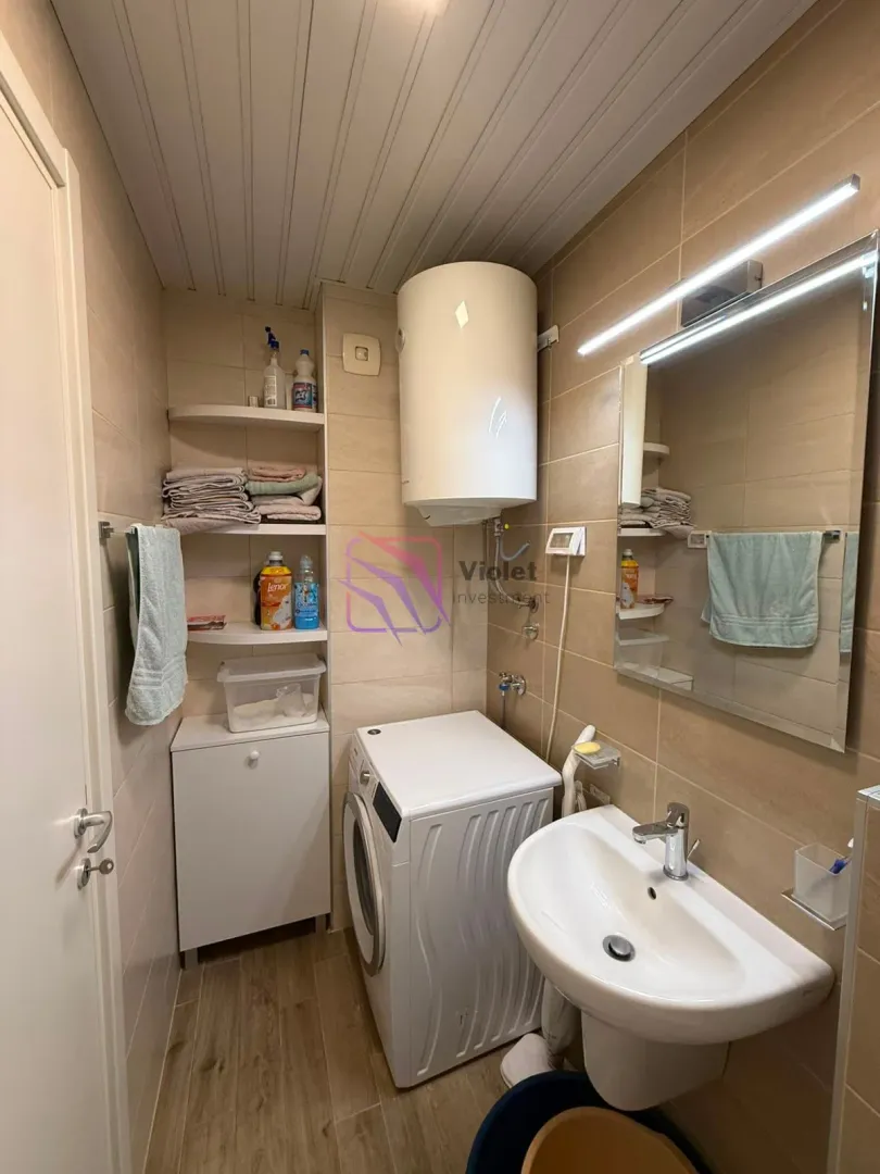 Compact bathroom with a washbasin, washing machine, and water heater.