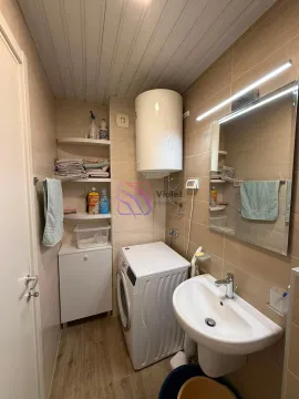 Compact bathroom with a washbasin, washing machine, and water heater. - image 10