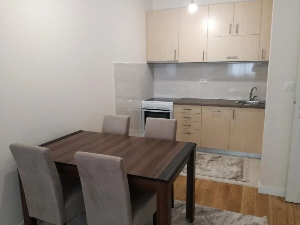 Small kitchen with wooden cabinetry and a dining table with four chairs.