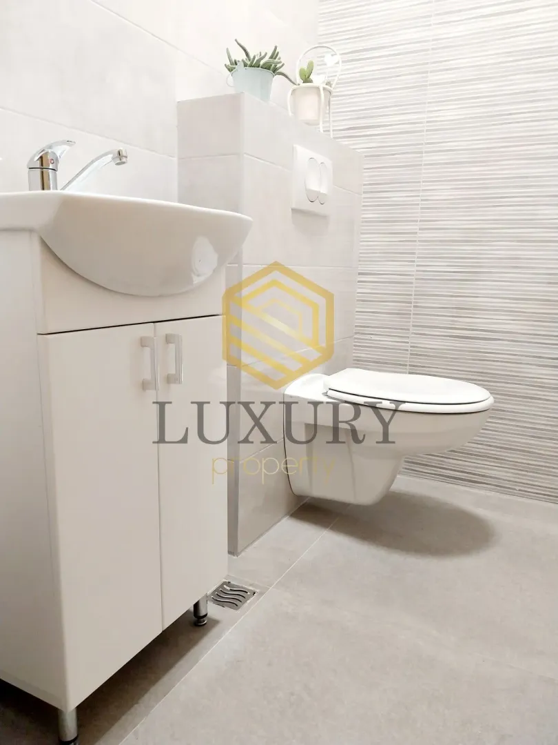 Modern bathroom equipped with a sink and toilet bowl.