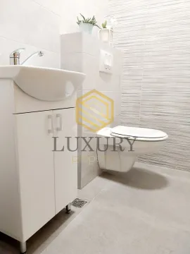 Modern bathroom equipped with a sink and toilet bowl. - image 6