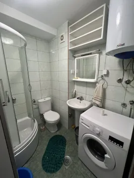A functional bathroom with a shower and washing machine. - image 7