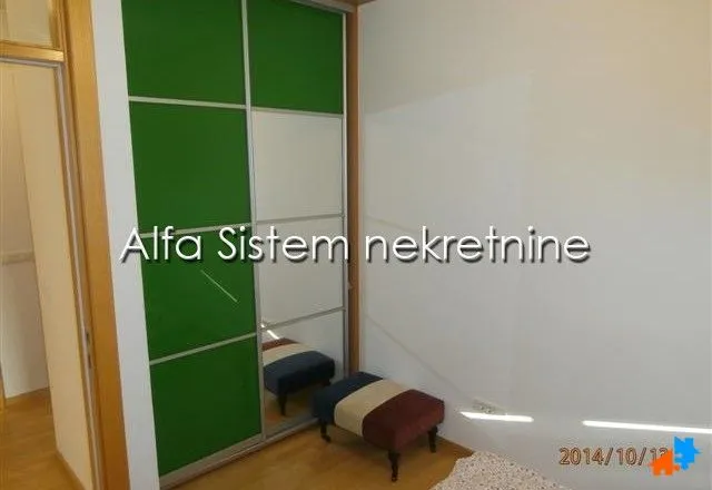 Spavaća soba sa ugradnim ormanom i klupom.