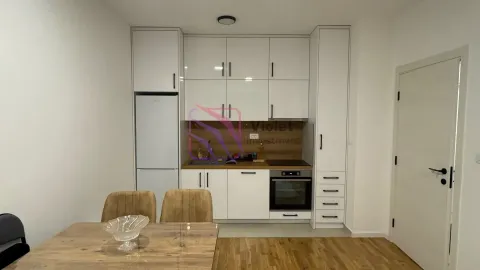 Kitchen with white cabinetry and a dining table. - image 7