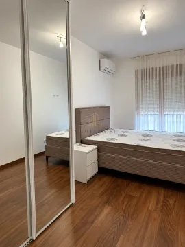 Spavaća soba sa bračnim krevetom, noćnim stočićem i velikim ogledalom na ormaru. - image 9