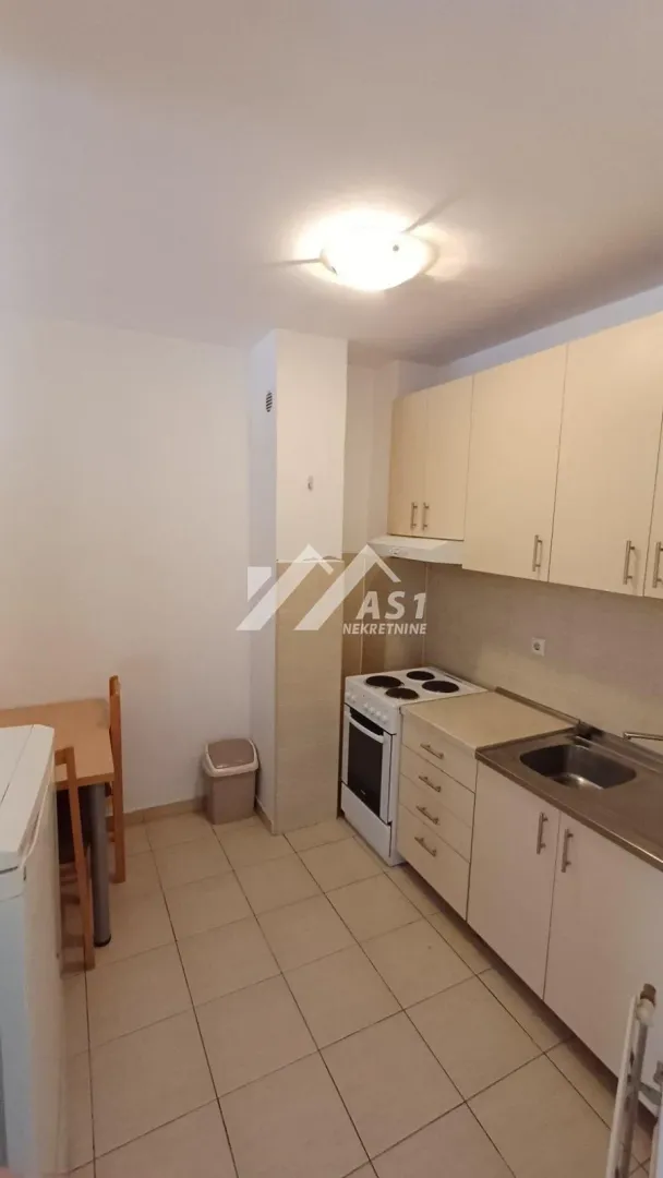 Small kitchen with white cabinets and a dining table.
