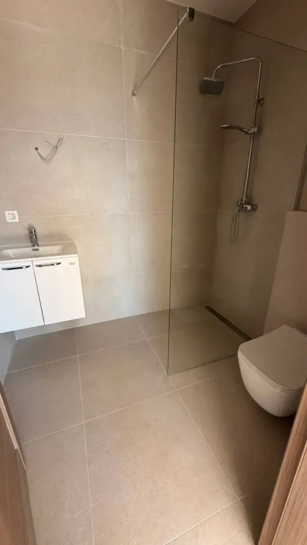 Moderne opremljeno kupatilo sa tuš kabinom.