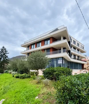 Exterior of a modern residential building with a landscaped yard and a for sale sign. - image 10