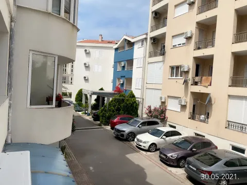 View from the apartment overlooking the courtyard and surrounding buildings with parked cars. - image 5