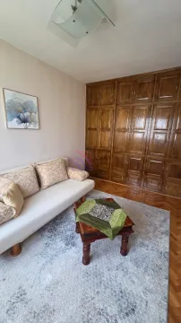 Dnevna soba sa kaučem, drvenim ormarom i malim stočićem. - image 3