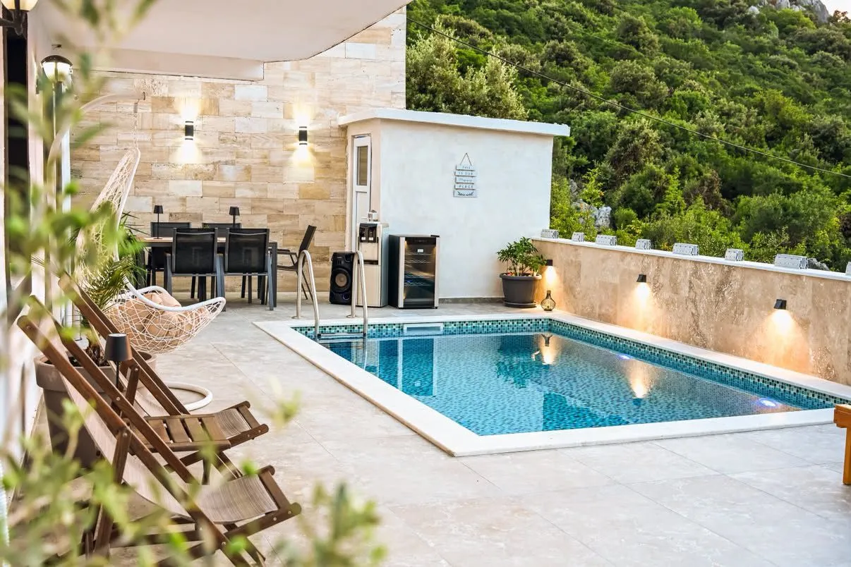 Terrace with a swimming pool, seating set, and sun loungers.