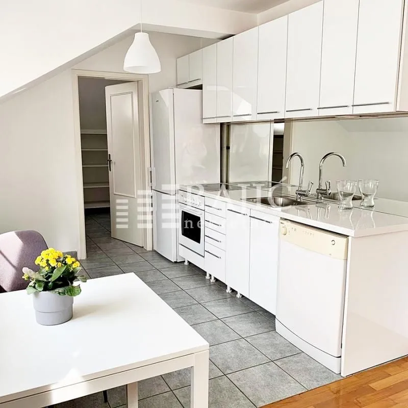 White kitchen with a dining table and a view of the apartment interior.