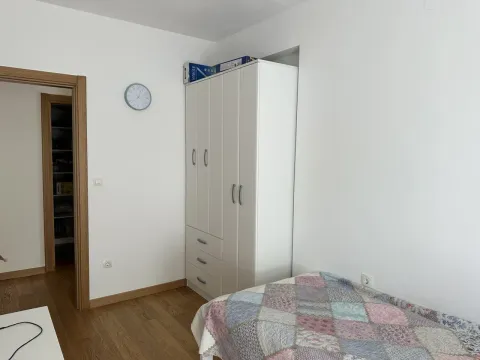 Manja spavaća soba sa krevetom, bijelim garderoberom i zidnim satom. - image 9