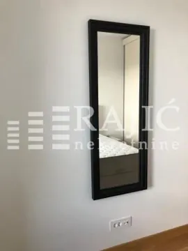 View of the wall with a mirror and bed in the bedroom. - image 9