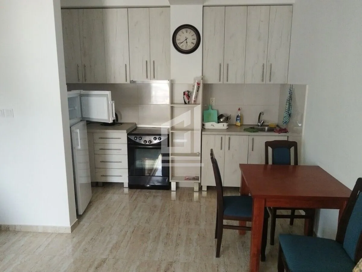 Kuhinja sa elementima u svijetloj boji i trpezarijskim stolom.