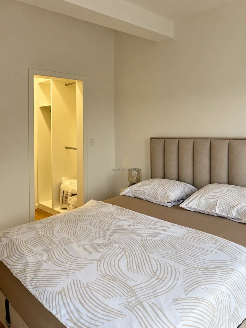 Bedroom with a double bed and a walk-in wardrobe entrance.