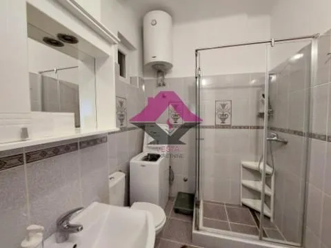 Bathroom equipped with a shower cabin, washbasin, toilet, and washing machine. - image 12