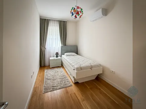 Small bedroom with a single bed, nightstand, and a window with curtains. - image 6