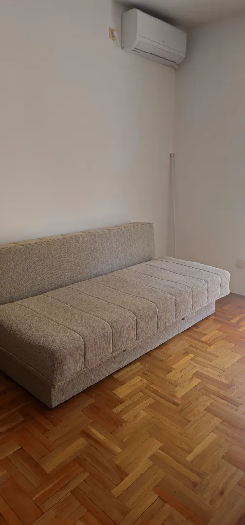 Soba sa kaučem i parketom.