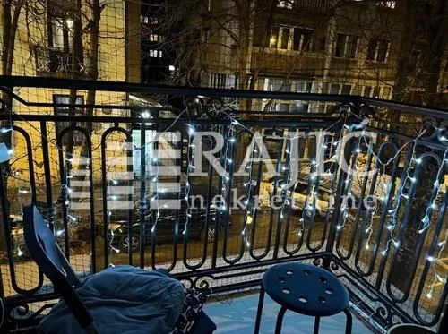 Balcony with decorative lighting and a view of surrounding buildings.