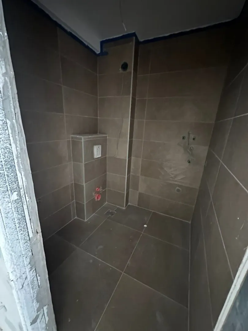 Kupatilo obloženo keramičkim pločicama u fazi uređenja.