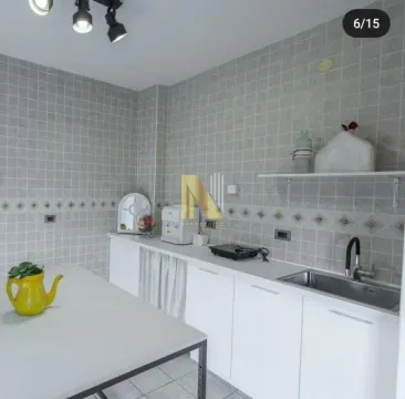 Smaller equipped kitchen with white units and grey tiles. - image 16