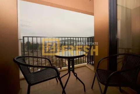 Covered terrace with a table, two chairs, and a view of the surroundings. - image 2