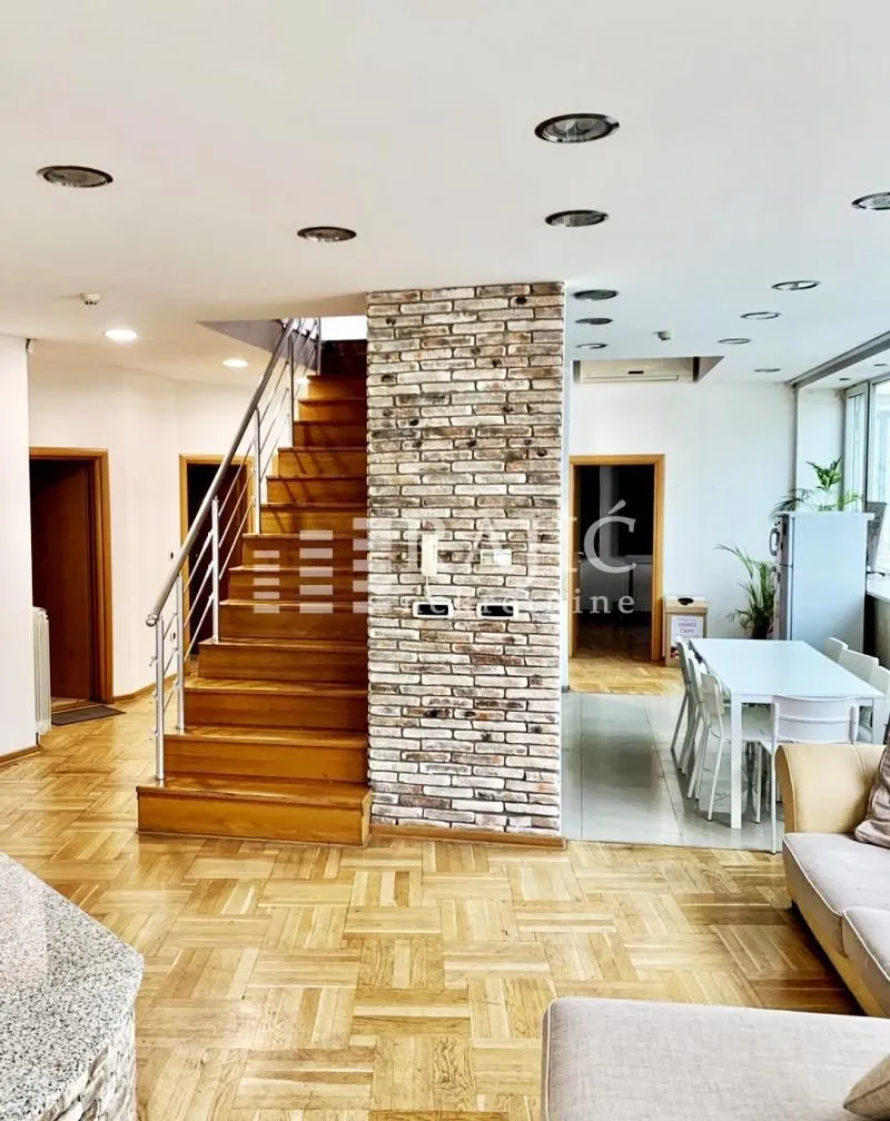 Living room with staircase and dining area.