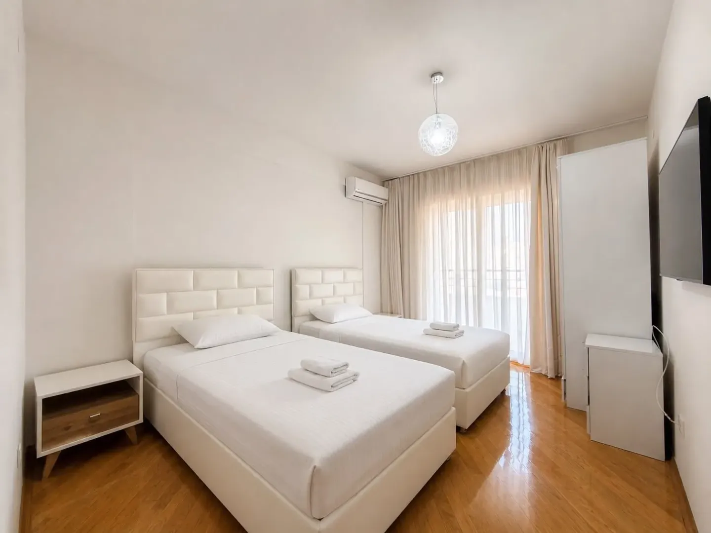 Bright bedroom with two single beds and a wardrobe.