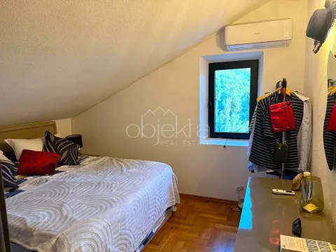 Furnished bedroom with sloping ceiling and wooden flooring. - image 10