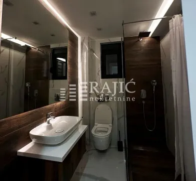 Modernly equipped bathroom with a walk-in shower and sink. - image 6