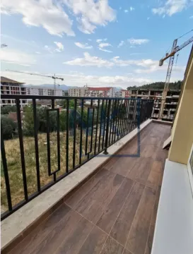 Long balcony with tiled flooring and a view of the city neighborhood. - image 6