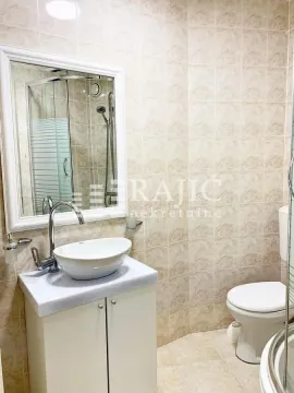 Small bathroom with a sink, mirror, and toilet. - image 2