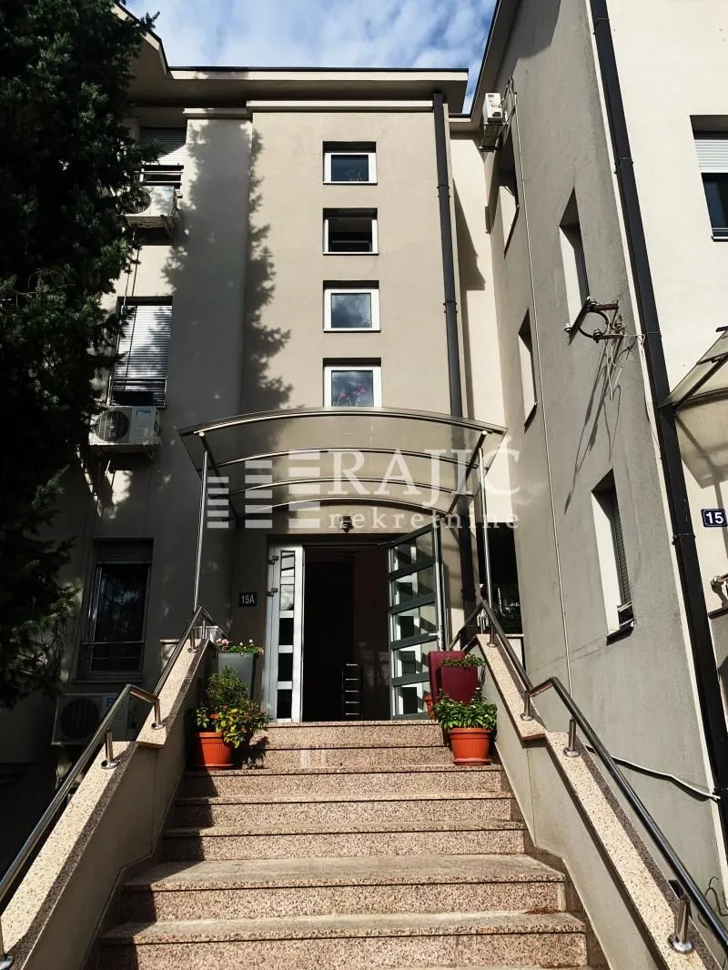 Ulaz u stambenu zgradu sa stepeništem i nadstrešnicom.