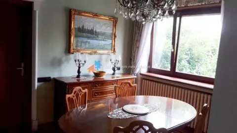 Dining room with a wooden table and chairs, a sideboard and a chandelier. - image 19
