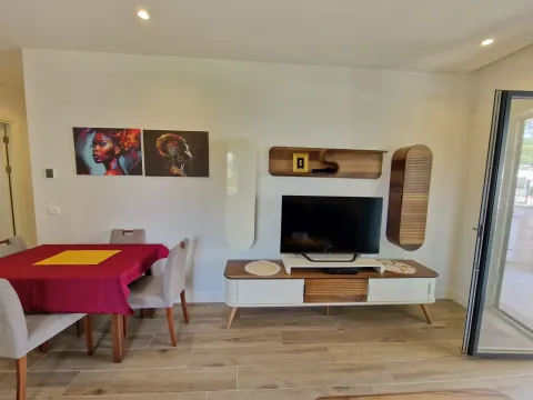 Living room with a dining table, TV unit, and modern paintings on the wall. - image 8