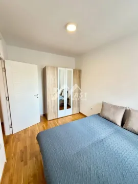 Nameštena spavaća soba sa bračnim krevetom i ormarom. - image 4