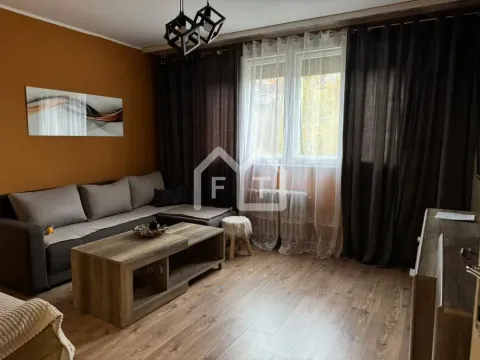 Living room with a sofa, coffee table, and a window with dark curtains. - image 3