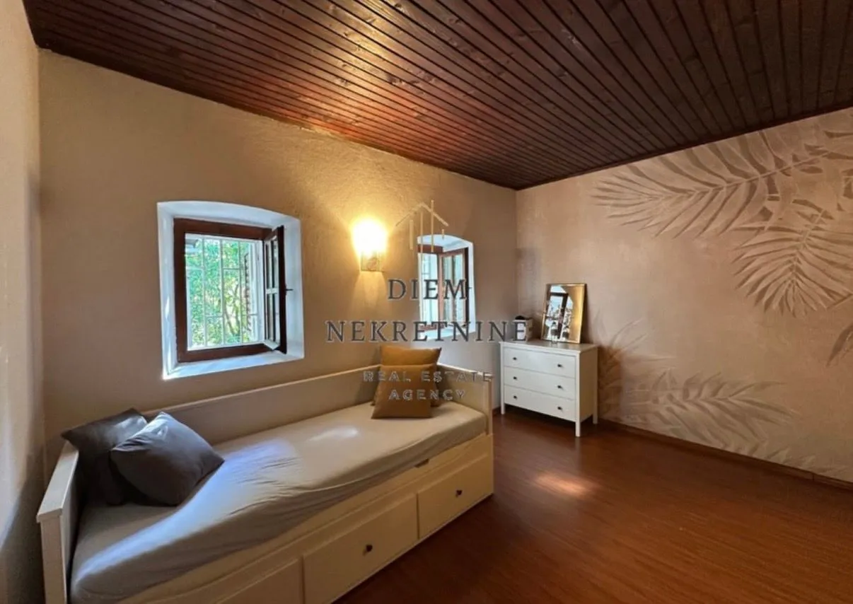Furnished bedroom with a bed and a wooden ceiling.