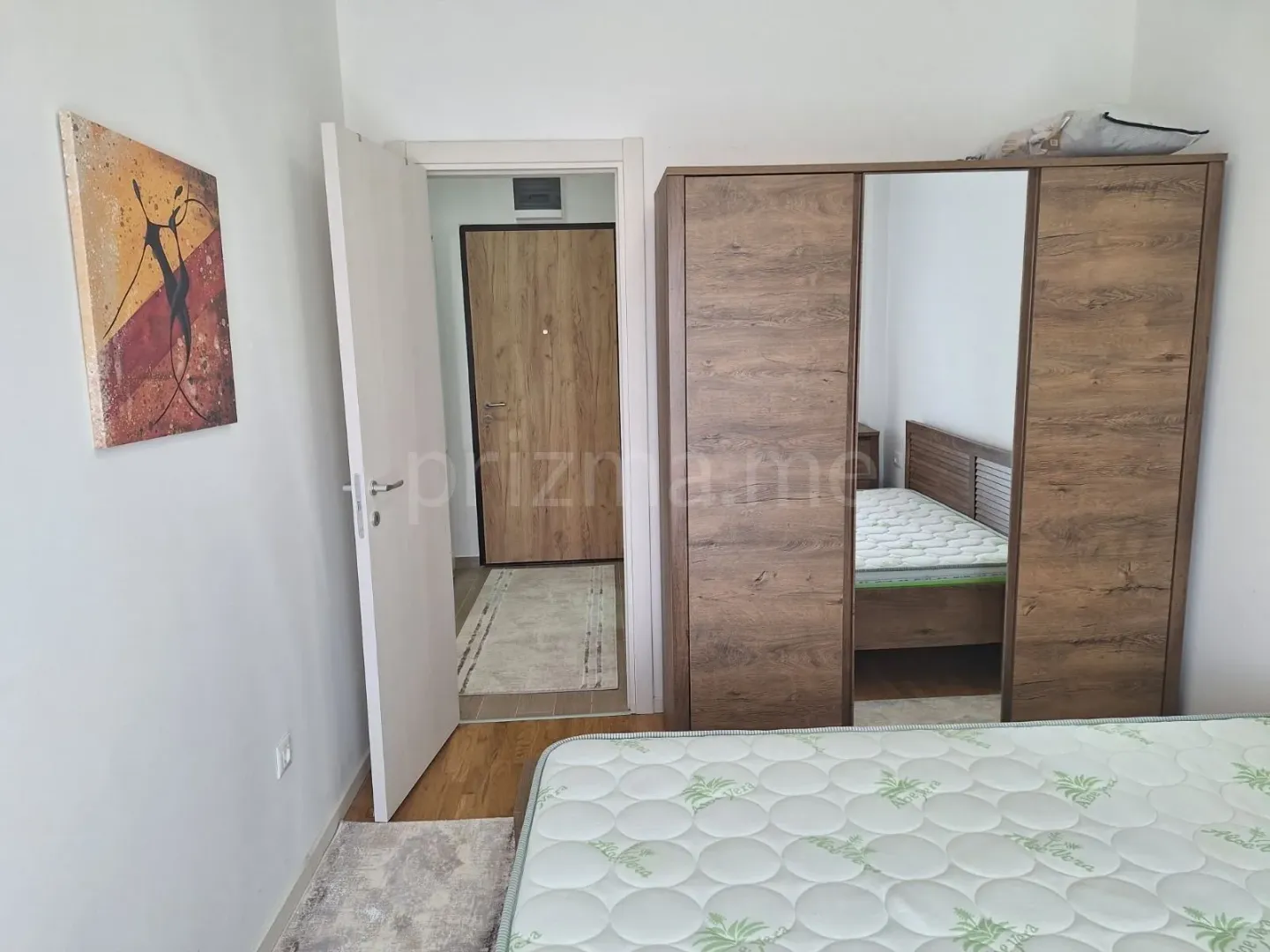 Furnished bedroom with a large wardrobe and a double bed.