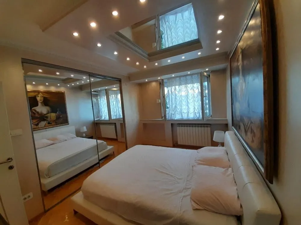 Bedroom with a double bed, a large mirror, and recessed ceiling lighting.