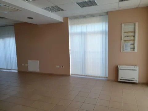 A spacious empty room with tiled flooring and vertical blinds. - image 14