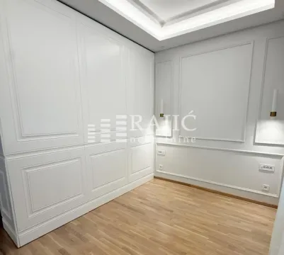 Modern bedroom with a built-in wardrobe and light wooden flooring. - image 5